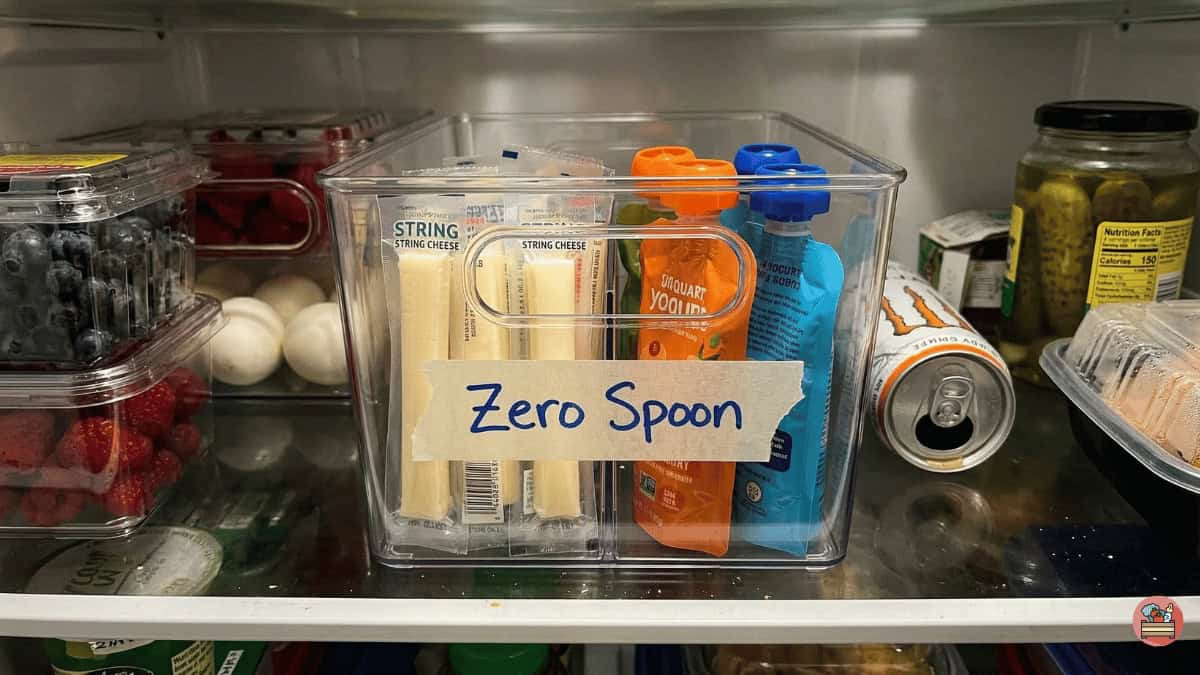 A real-life ADHD fridge organization system showing a 'Zero Spoon' snack bin at eye level.