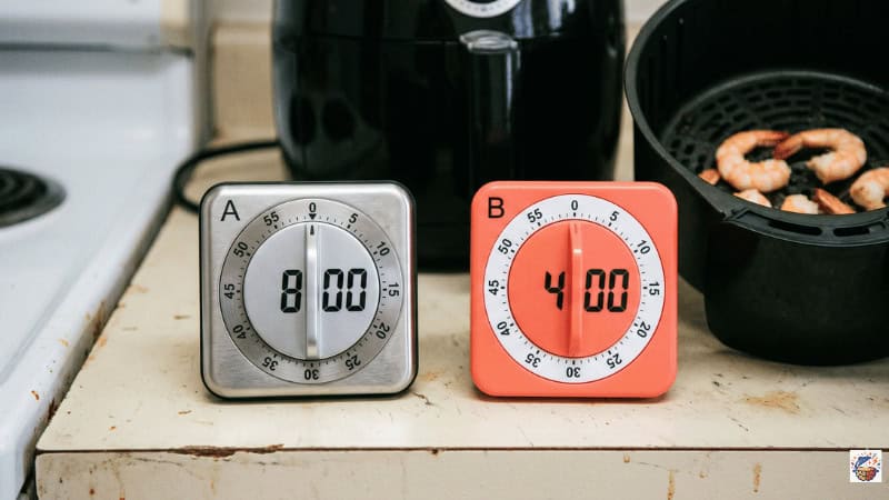Two kitchen timers set for air fryer shrimp cook time and mid-cook shake reminder under 10 minutes