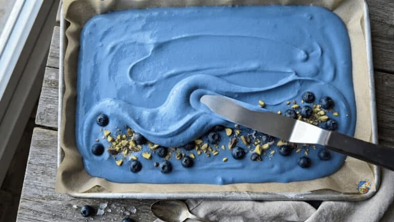 spreading blue-tinted yogurt onto a lined tray