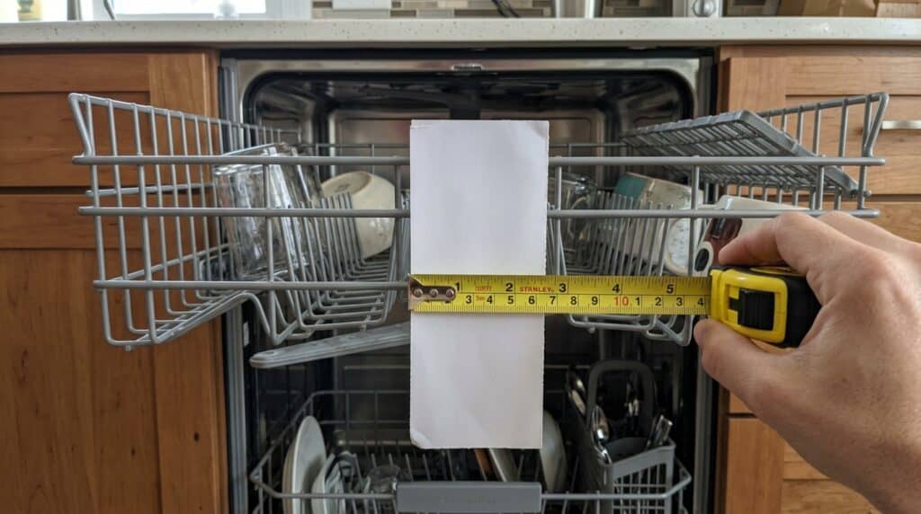 Half sheet pan measured against a standard dishwasher upper rack