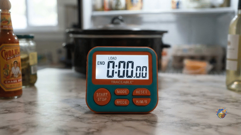 Digital timer on the counter at the end of a night load, slow cooker insert behind it