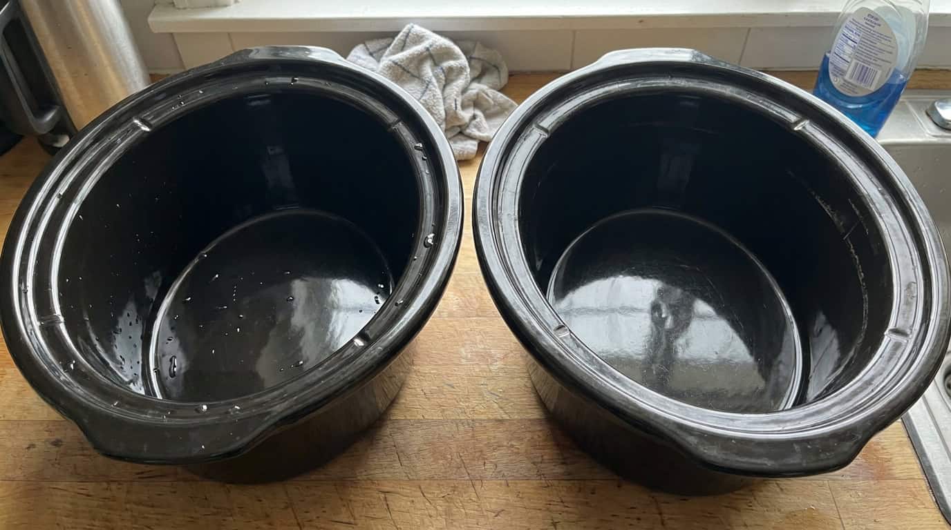 Two slow cooker inserts side by side on a counter after washing