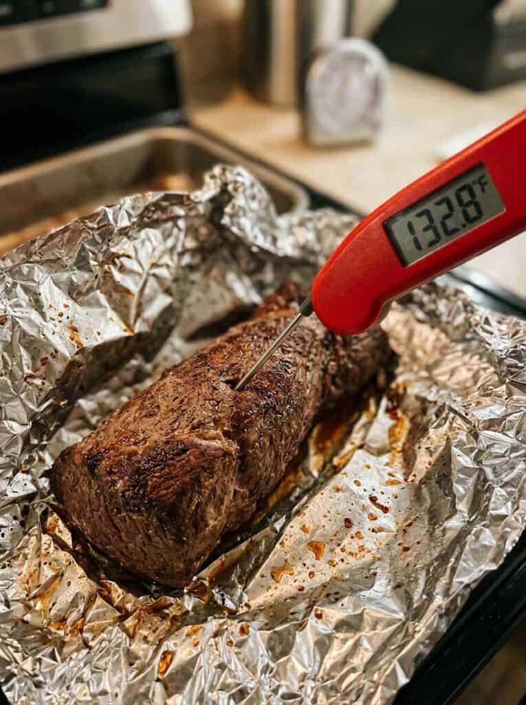 Instant-read thermometer in the thickest chicken tenderloin of a baked broccoli rice casserole